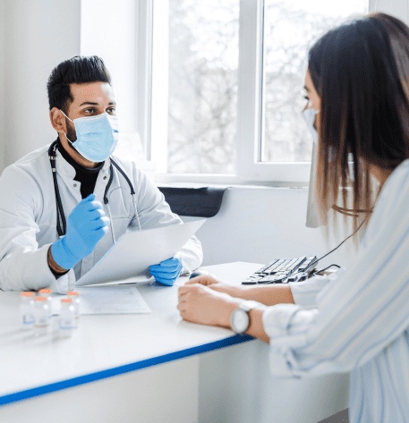 Indian doctor receives patient tells him about results,tests and medicine